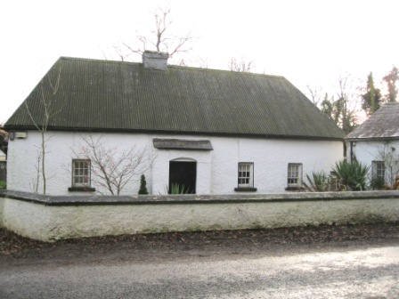 Old style mud walled farmhouse at Lionsden, Longwood. This house is whitewashed and would originally have been thatched. There is a hand pump for water in front of the house (photo by Joan Mullen)